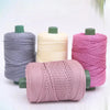 A collection of pink, beige, and gray 3mm ice rope crochet yarn spools for crafting.