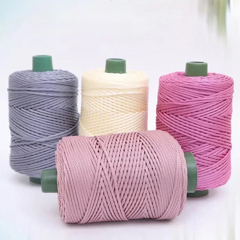 A collection of pink, beige, and gray 3mm ice rope crochet yarn spools for crafting.