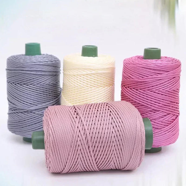 A collection of pink, beige, and gray 3mm ice rope crochet yarn spools for crafting.