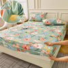 A floral fitted sheet set with green and pink flowers is displayed on a bed, showing a close-up of the fabric pattern.