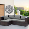 A dark brown wicker outdoor sofa with gray cushions is shown against a modern building and sunset backdrop.