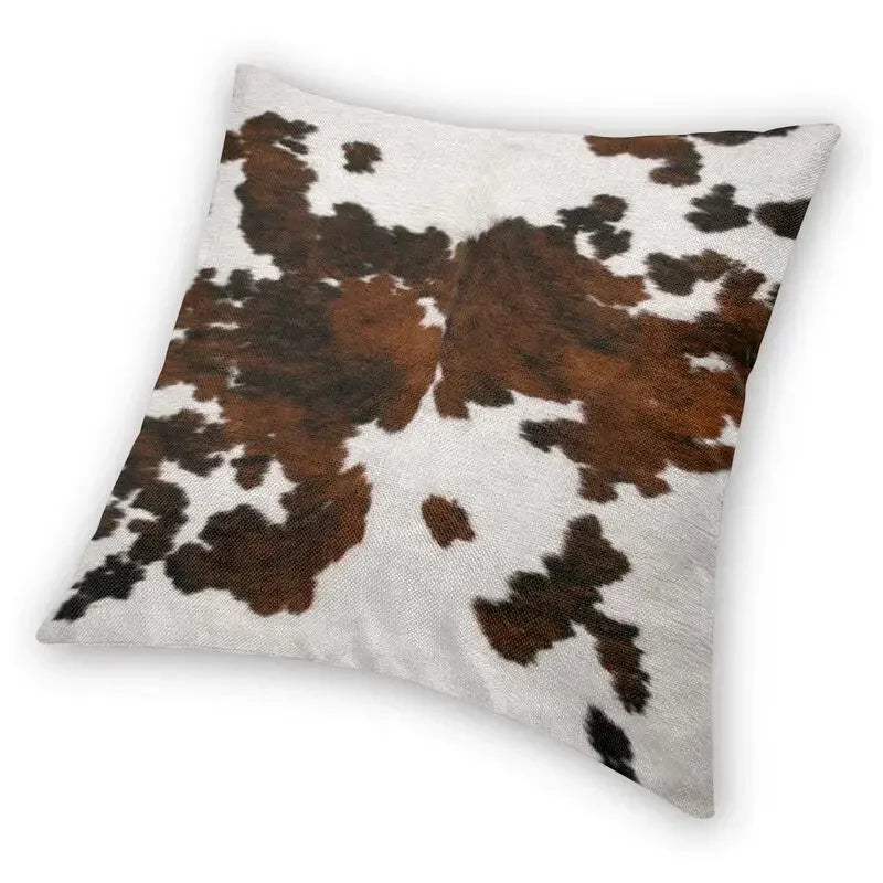 A square cushion cover featuring a brown and white cowhide print.