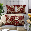 A set of red floral embroidered pillow covers featuring white and deep red flowers on a neutral sofa.