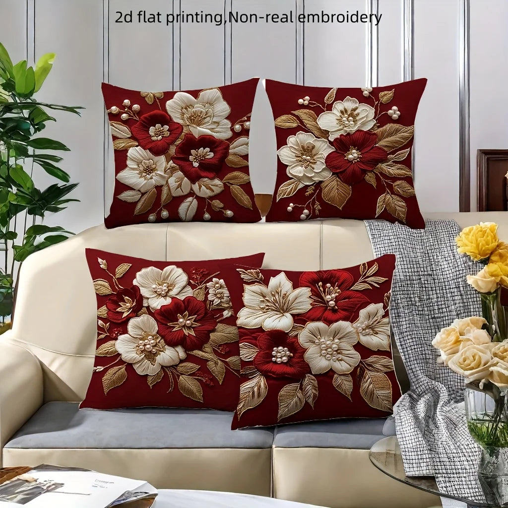 A set of red floral embroidered pillow covers featuring white and deep red flowers on a neutral sofa.