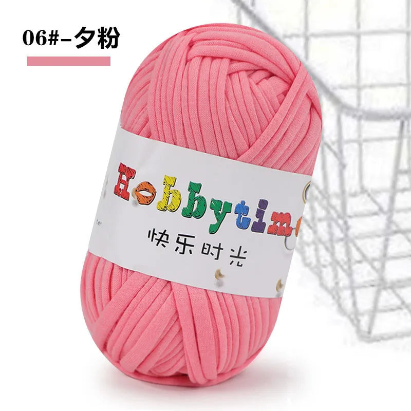 Pink thick polyester craft yarn skein with a white label and a wire mesh background