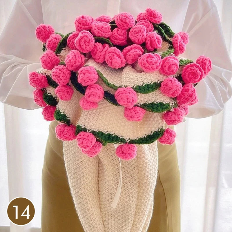 Hand knitted floral rose bouquet throw blanket in pink and green yarn displayed on a white sleeve.