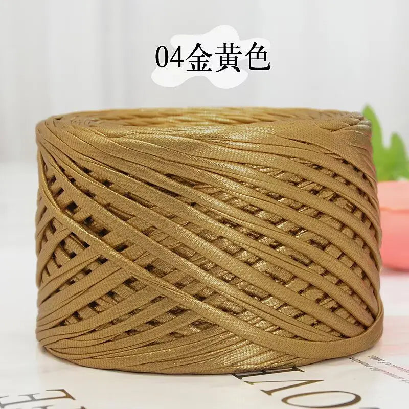 A spool of metallic gold cake yarn for crafting, tightly wound and cylindrical.