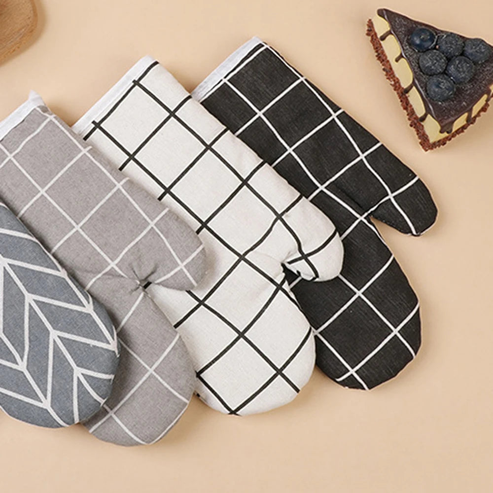 A set of heat-resistant kitchen oven gloves in gray, black, and white checkered patterns.