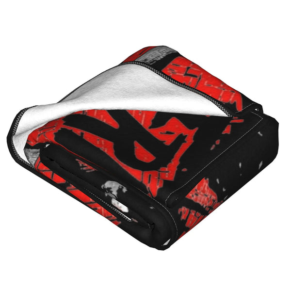 A black fleece throw blanket featuring a red horror movie graphic design and a white sherpa lining.