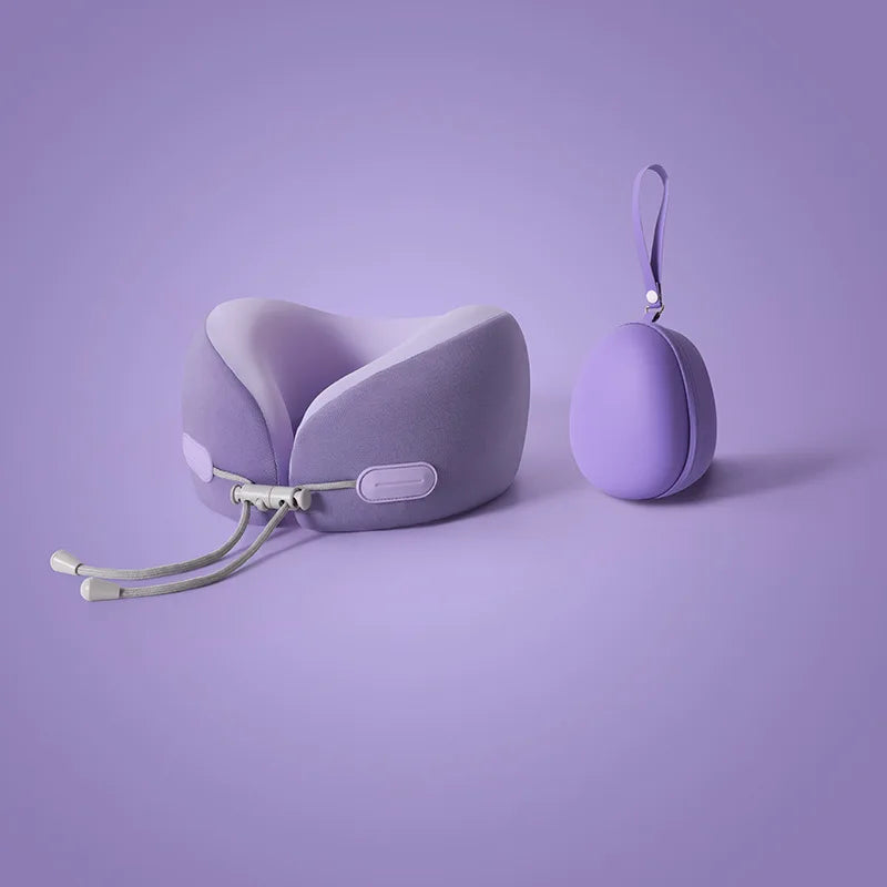 A purple U-shaped memory foam travel neck pillow with a strap is shown against a light purple background.