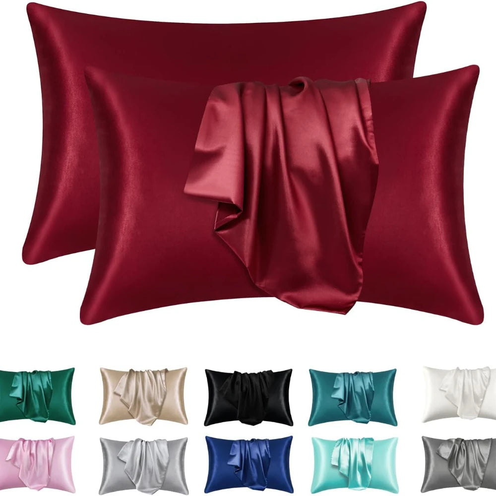 A set of deep red satin pillowcases, including a standard pillowcase and a decorative rolled accent.