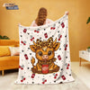 A white flannel blanket featuring a cartoon Highland cow print with red pepper cans and leaves.