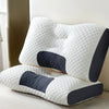 A white ergonomic contour neck pillow with dark gray accents resting on a light surface.