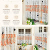 Elegant white lace cafe curtain featuring orange floral embroidery and butterfly applique hanging in a window.