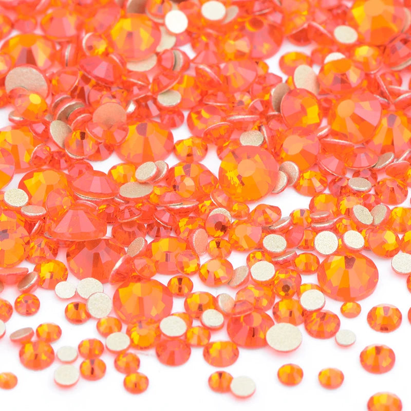 A pile of small, round, orange-colored glass rhinestones for DIY crafts.