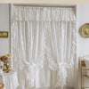 White French Rococo vintage lace curtains hanging in a window frame.
