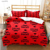 A red duvet cover set with black MCM pattern featuring embroidered symbols and pillows on a bed.