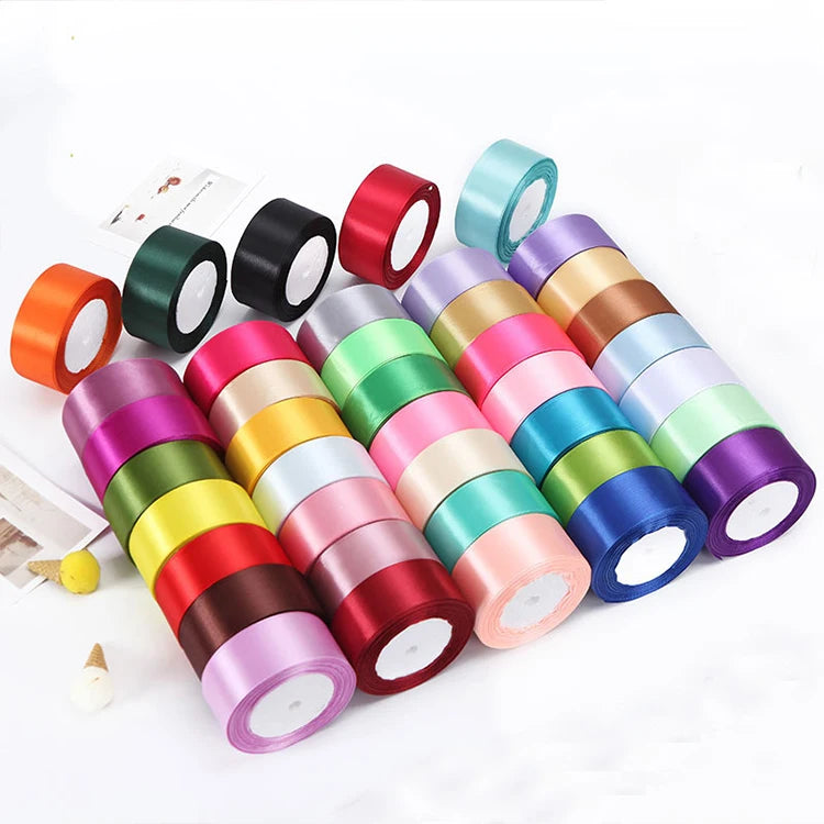 A collection of colorful satin ribbon rolls in various shades including pink, green, blue, and red for crafts and gift wrappi