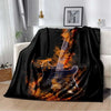 A black flannel blanket featuring an orange and yellow guitar design.