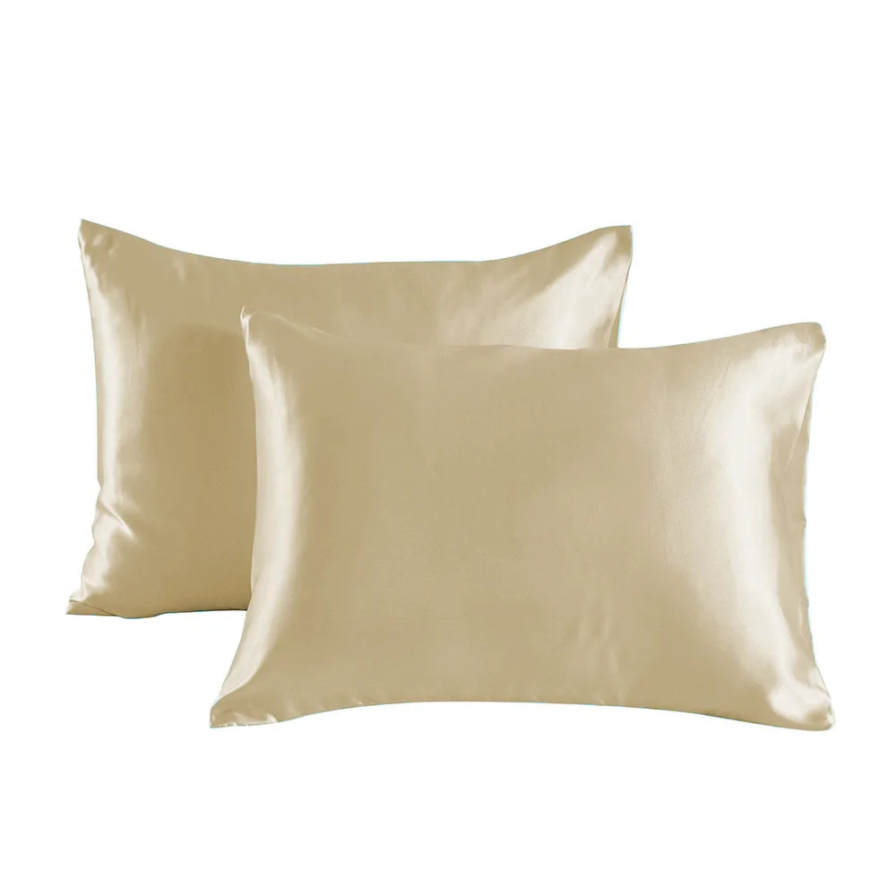 Two smooth satin pillowcases in a champagne or beige color.