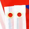 White fabric with vertical stripes and gold grommets against a red background.