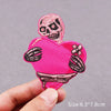 Pink embroidered patch featuring a skull and a heart design