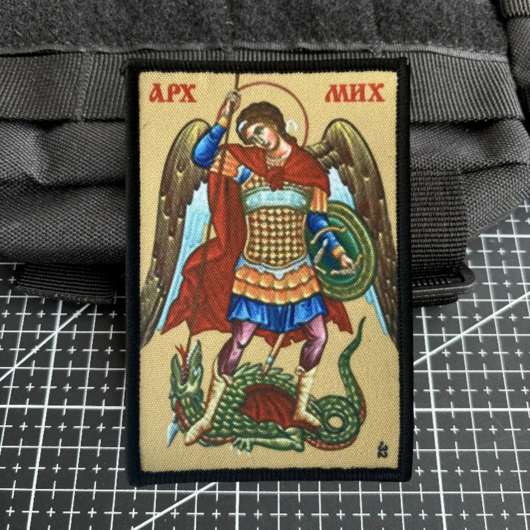 An embroidered patch depicting the Archangel Michael with a hook and loop backing.
