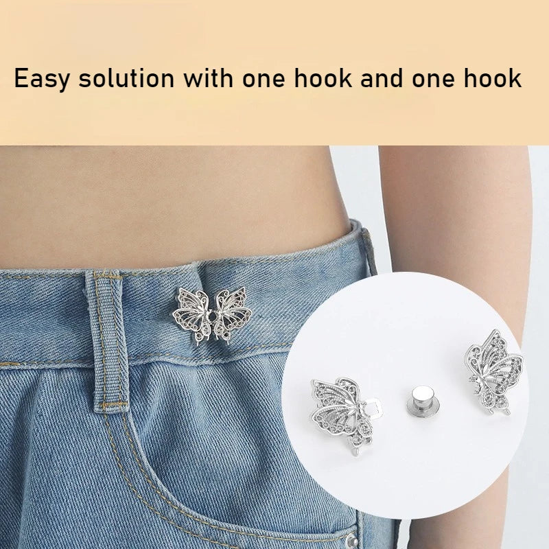 A close-up of an adjustable butterfly button waist tightener for pants and skirts being used on denim fabric.