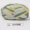 A ball of hand-dyed fabric strip yarn featuring shades of yellow, green, and beige.