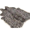 A rectangular rug made of modern faux animal skin with a leopard print pattern.