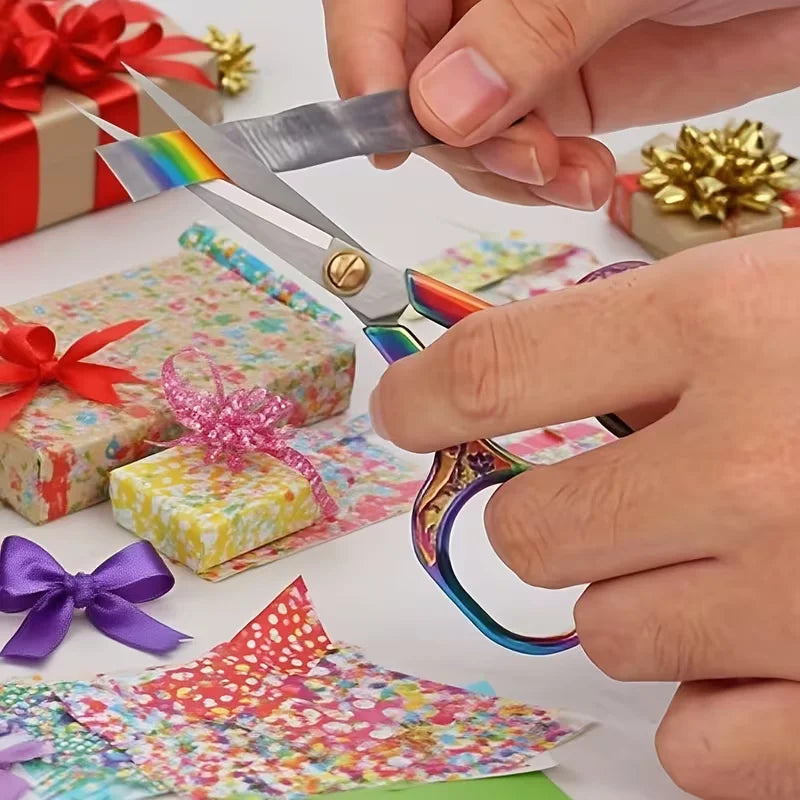 Hands are using stainless steel vintage sewing scissors to cut fabric and embroidery pieces.