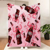 A pink cozy blanket featuring a repeating pattern of Dr. Pepper bottles with pink ribbons.