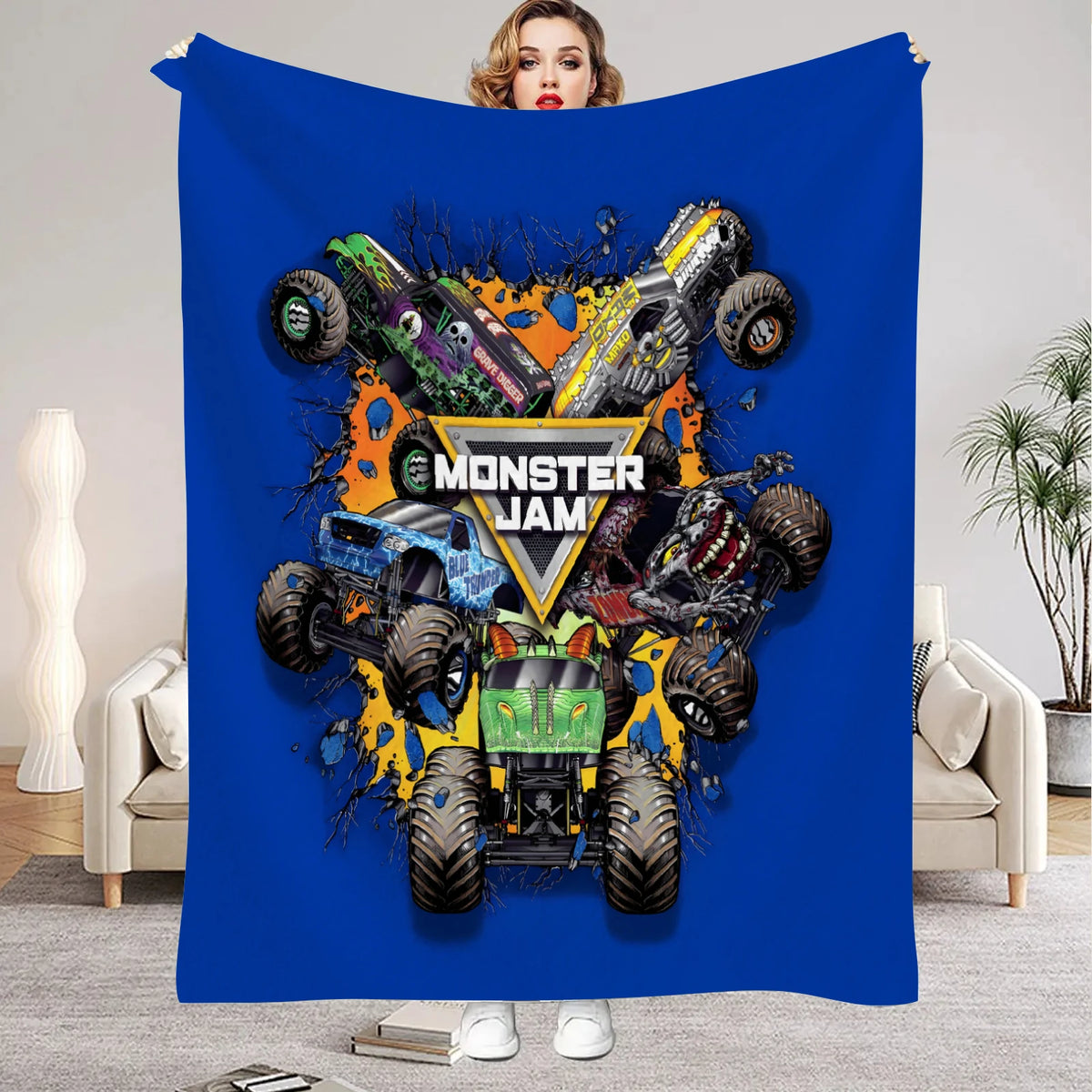 A blue flannel throw blanket featuring a graphic of Monster Jam vehicles and a woman's face.
