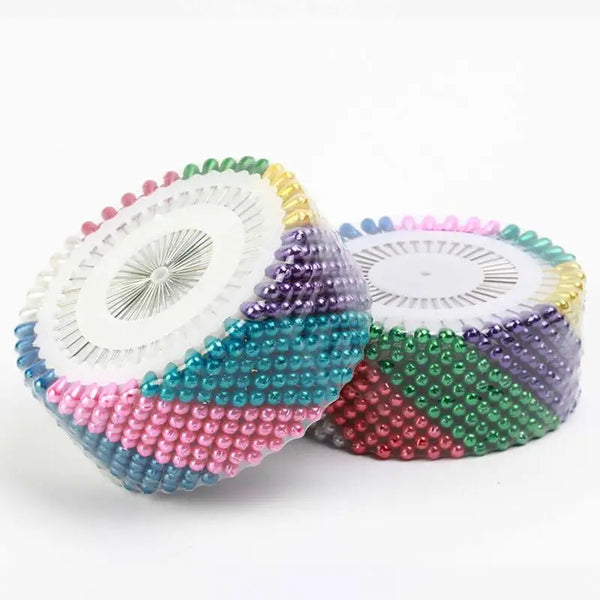 A set of colorful pearl straight head pins for crafting arranged in a fan shape.