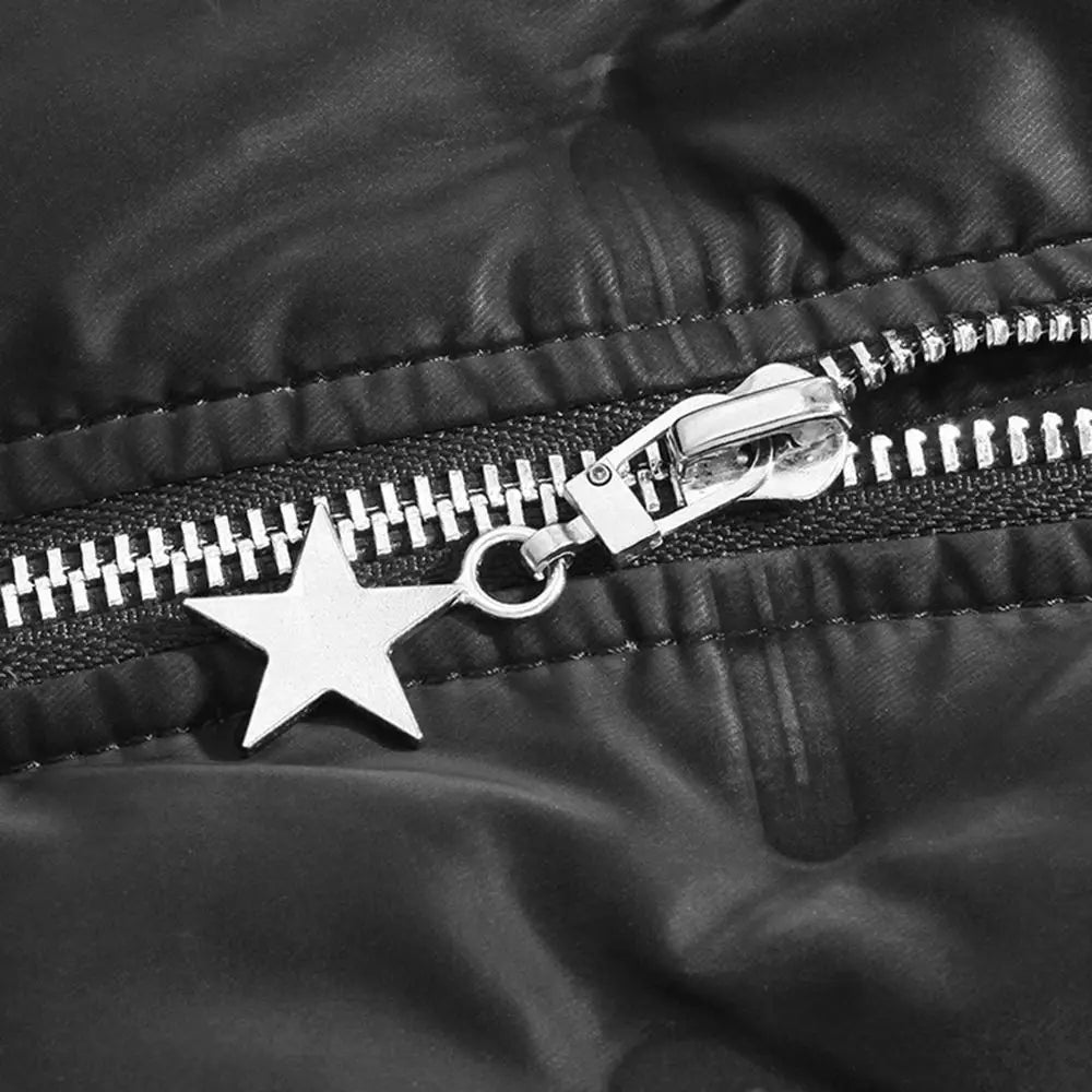 Close-up of a black quilted fabric with a silver metal zipper pull featuring a star charm.
