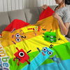 A colorful throw blanket featuring cartoon characters and stripes, being held by a person.