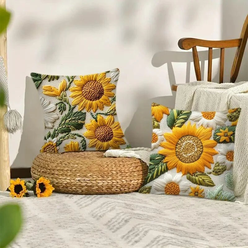 A decorative cushion featuring a sunflower pattern in yellow and green on a white background.