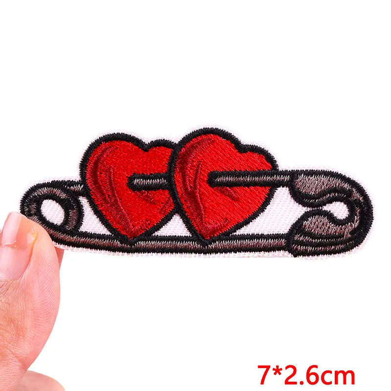 Red heart embroidered iron-on patch featuring two hearts on a black line