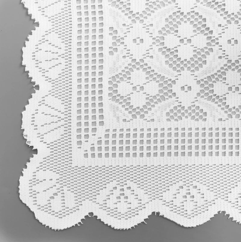 White lace table runner featuring a geometric and floral pattern on a gray background.