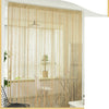 Glitter fringe door curtain in beige hangs over a window, decorated with natural light and indoor plants.