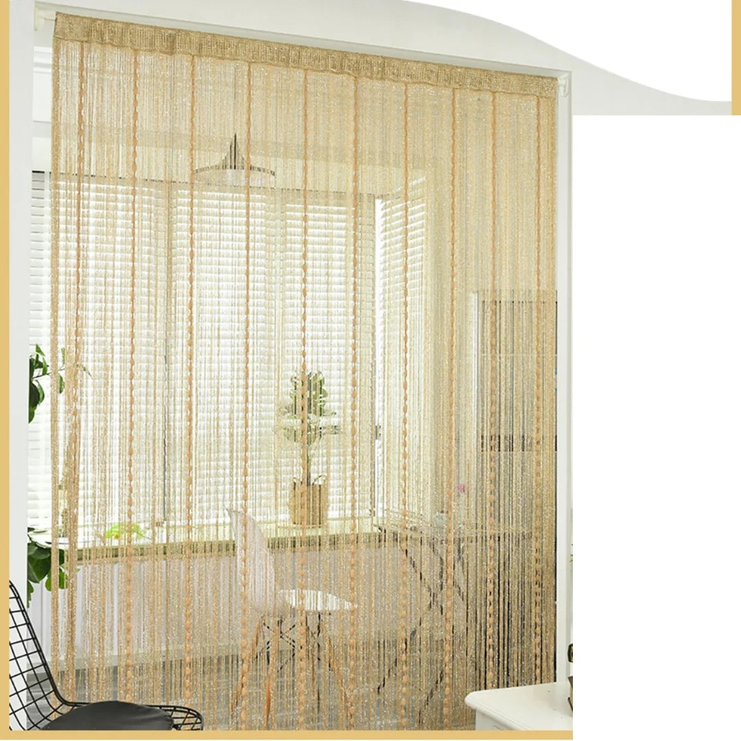 Glitter fringe door curtain in beige hangs over a window, decorated with natural light and indoor plants.