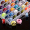 A collection of pre-wound sewing machine bobbins with thread in various colors arranged in a clear plastic tray.