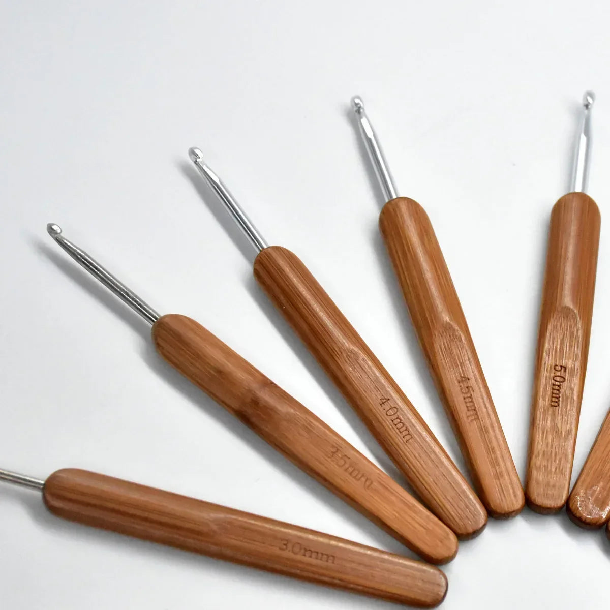 A set of wooden bamboo crochet knitting needles in various sizes, including 4.0mm, 5.0mm, and 5.5mm.
