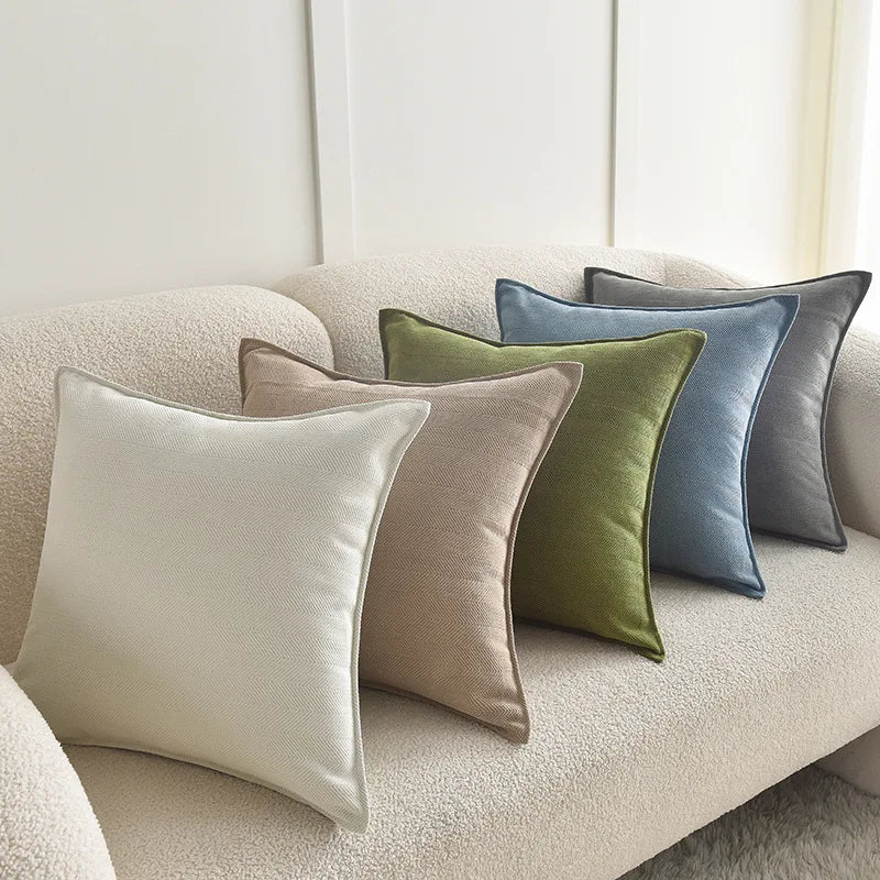 A collection of luxury chenille throw pillow covers in muted tones including beige, olive green, and dusty blue.
