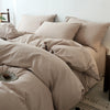 A beige cotton yarn-dyed duvet cover is displayed on a bed with matching pillows and bedding.