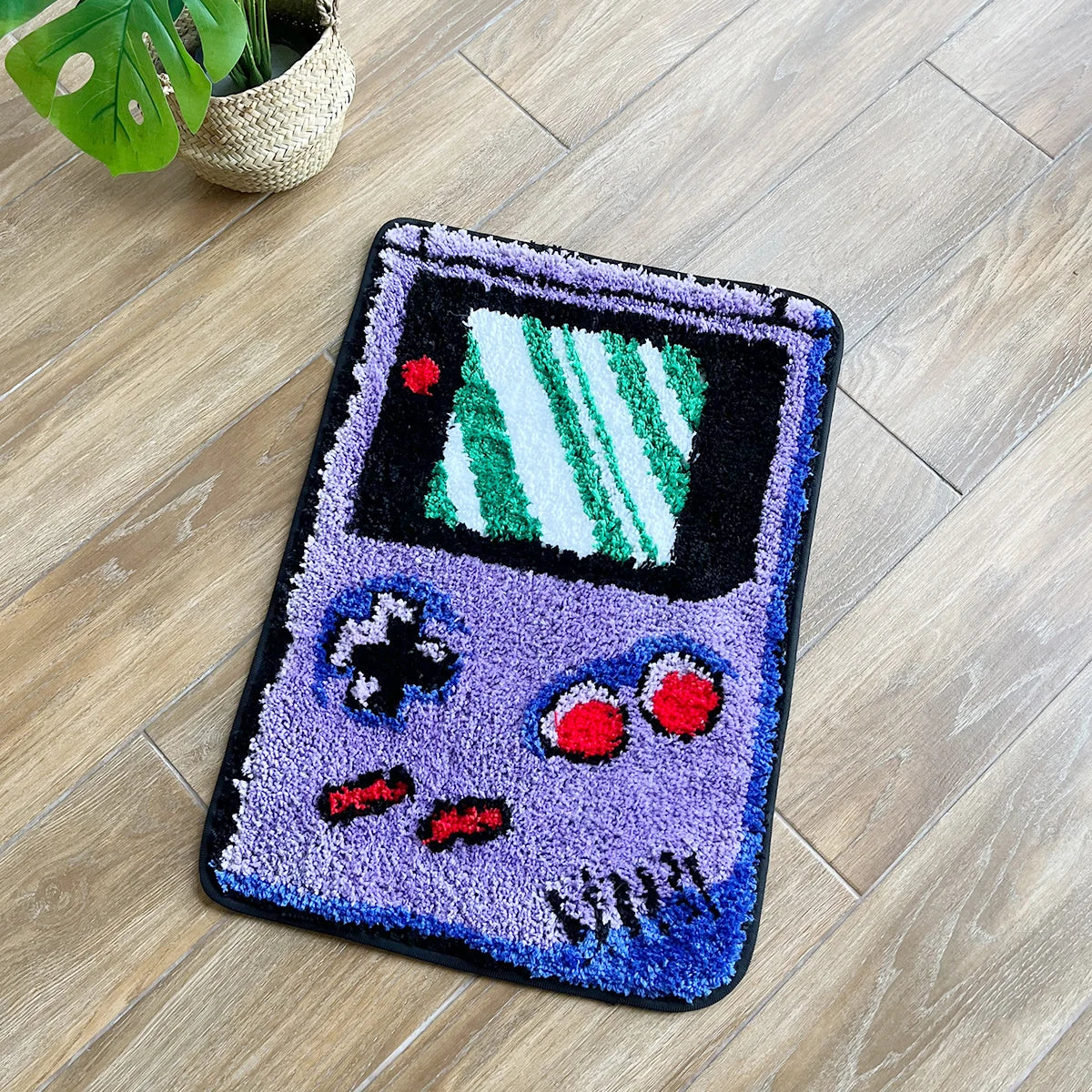 A purple tufted floor mat shaped like a retro video game controller with green and white graphics.
