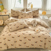 A beige duvet set featuring a cute dog print pattern, complete with pillows and a stuffed animal.