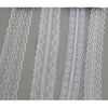 A close-up view of various white floral hollow-out lace ribbons for sewing and DIY crafts.