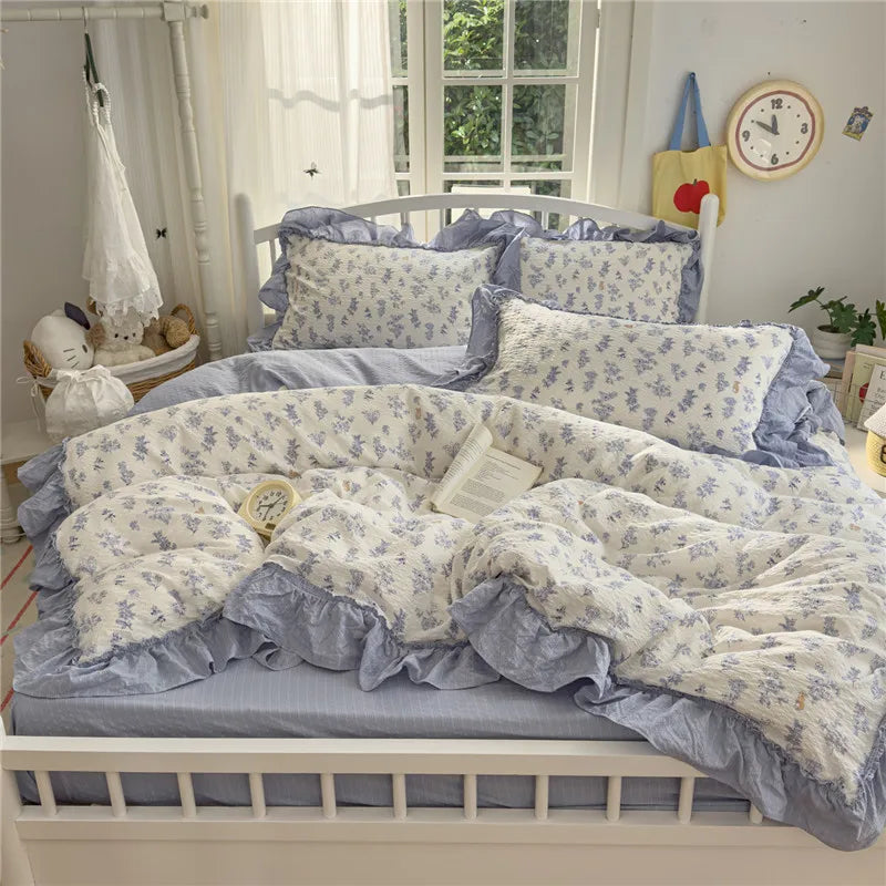 A light blue princess style ruffle bedding set with white floral patterns on a wooden bed frame.