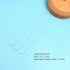 A set of three stainless steel beading needles laid diagonally on a light blue surface.